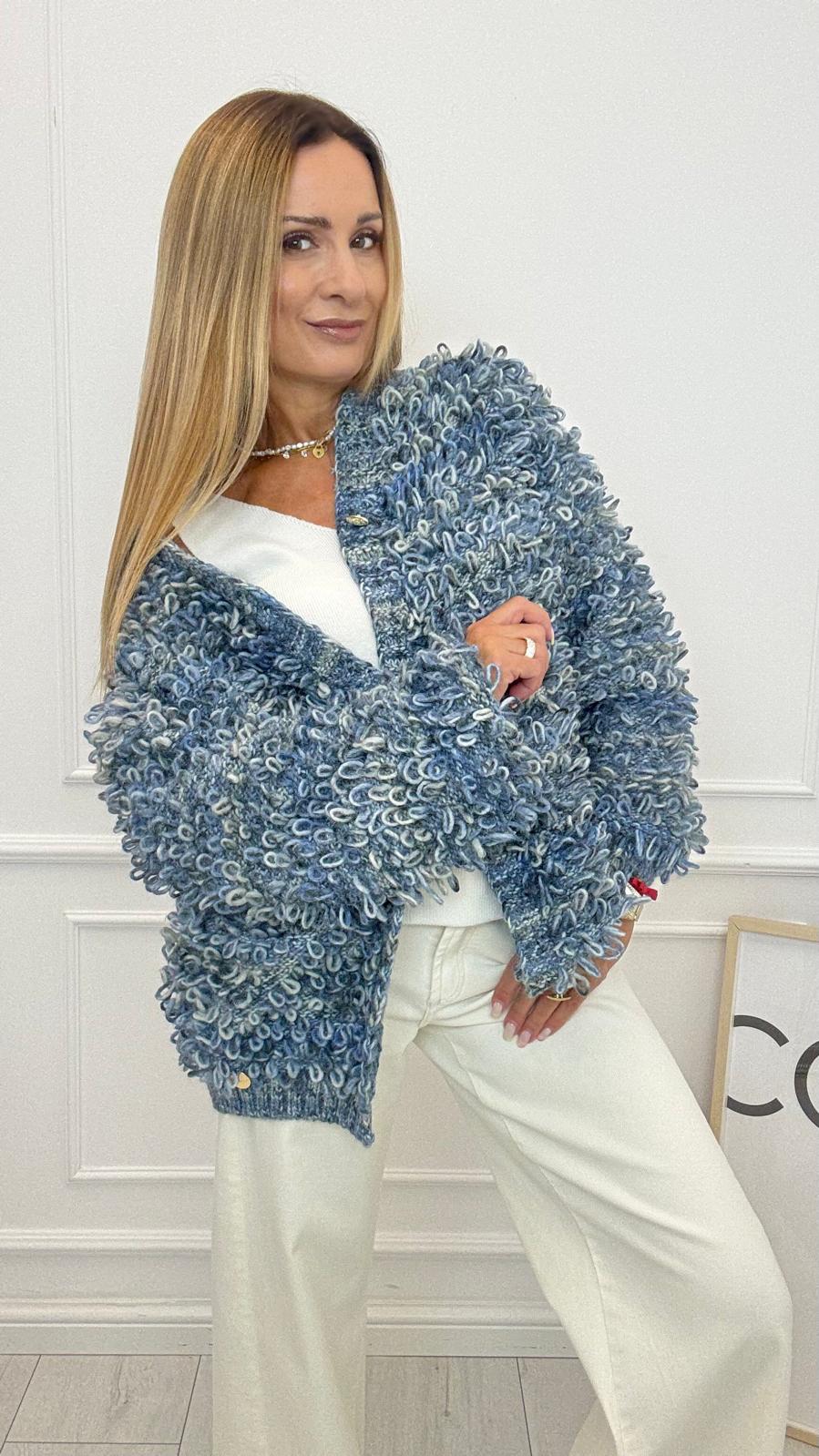 Sweter o luźnym kroju, wykonany z miękkiej dzianiny z charakterystycznym splotem typu „loop”, który nadaje mu wyrazistej faktury. Model z długimi rękawami i wygodnym fasonem świetnie sprawdza się zarówno na co dzień, jak i jako oryginalny akcent w stylizacjach wieczorowych. Multikolor sprawia, że sweter przyciąga wzrok i dodaje wyjątkowości  każdej stylizacji. Idealny do noszenia z basicowymi topami, jeansami lub spódnicami – pozwala wyróżnić się i podkreślić indywidualny styl.